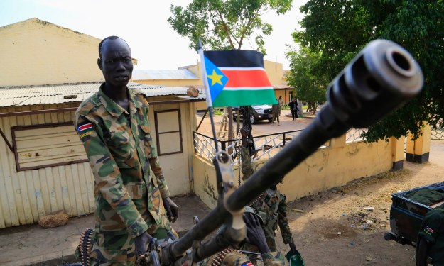 A South Sudan army soldier stands next to machine gun mounted on truck in Malakal town